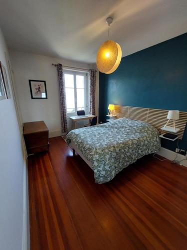 埃维昂莱班Le Mirabeau Vue Lac的一间卧室设有一张床和蓝色的墙壁