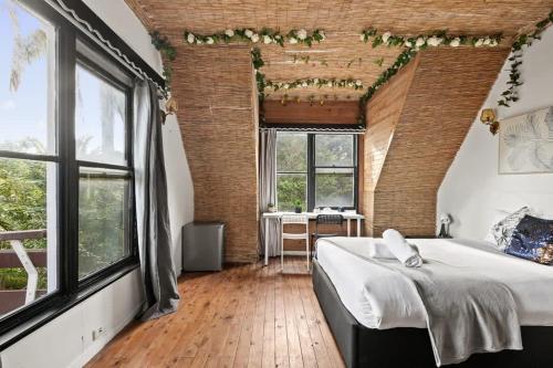 悉尼Private Room in Sans Souci Guesthouse的一间卧室设有一张大床和大窗户