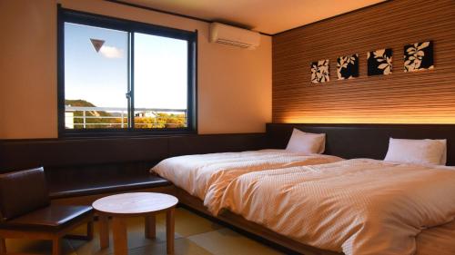 大町市梦之汤酒店的一间卧室设有两张床和窗户。