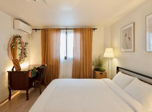 首尔Juin - Foreigner only的一间卧室配有一张床、一张书桌和一个窗户。