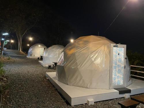 加央Gunung Medan Glamping & Cafe的一群帐篷在晚上在田野里