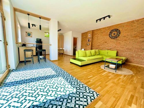SohodolCasa Aluna Duo的客厅设有绿色沙发和砖墙