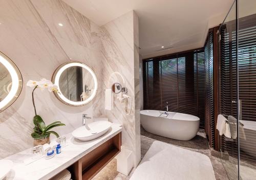 吉隆坡Sunway Resort Hotel的带浴缸、水槽和镜子的浴室
