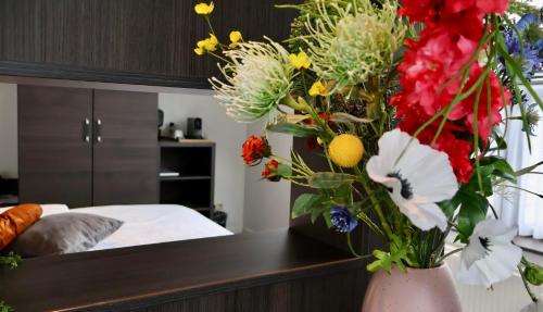 Appeltern默尔克莫伦酒店的卧室里一个满是鲜花的花瓶