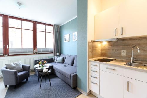 瓦尔内明德斯特兰德纳公寓的带沙发的小客厅和厨房