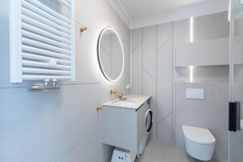 博格泽利卡HEVENIA POGORZELICA - APARTAMENT 2的白色的浴室设有卫生间和镜子