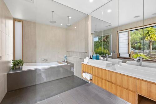 托基Swim spa and play tennis at Relaxing family retreat的一间带两个盥洗盆和大镜子的浴室