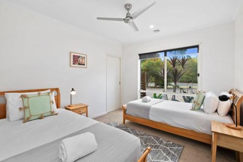 托基Swim spa and play tennis at Relaxing family retreat的一间卧室设有两张床和窗户。