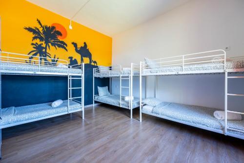 拉戈斯The Macarena Beach Hostel的客房设有三张双层床和黄色墙壁