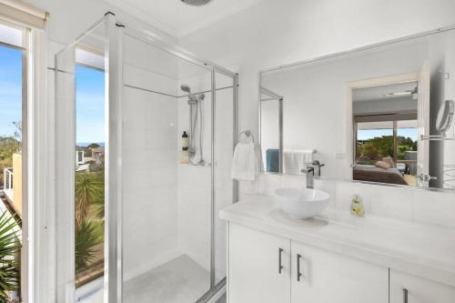托基Stunning ocean views indoor spa and sun deck的白色的浴室设有水槽和淋浴。