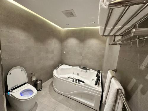 乌姆莱季فندق حياة تاون املج 1的带浴缸、卫生间和盥洗盆的浴室