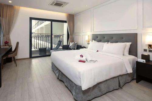 岘港Goldenbay Danang 1 Bedroom Apartment的一间大卧室,配有一张白色的大床和一张书桌