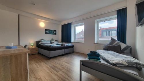 海尔布隆Boardinghouse Heilbronn的一间卧室配有一张床、一张沙发和两个窗户。