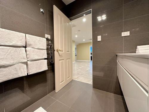 霍巴特City Retreat for 8 with Spacious Rooms的一间带白色门和毛巾的浴室