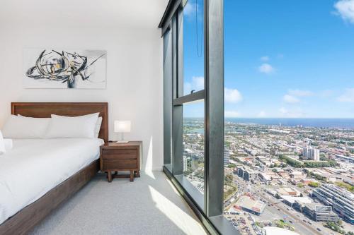 墨尔本Breathtaking Views 49th floor - Melbourne Square的一间卧室设有一张床和一个大窗户