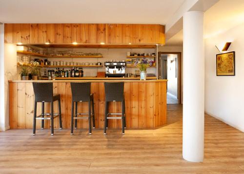 比斯卡罗斯亚特兰迪德酒店的厨房配有木制橱柜和酒吧凳子