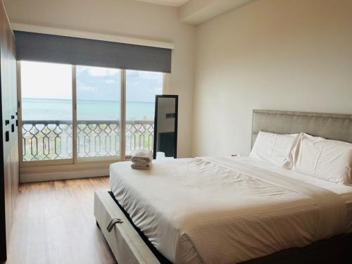 拉斯阿尔卡麦Bab Al Bahr Residence - Blue Collection Holiday Homes的一间卧室设有一张床,享有海景