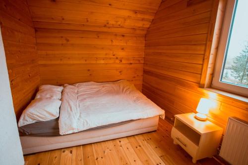 PāleBrīvdienu māja Straumēni的一间小卧室,配有一张位于木制房间内的床