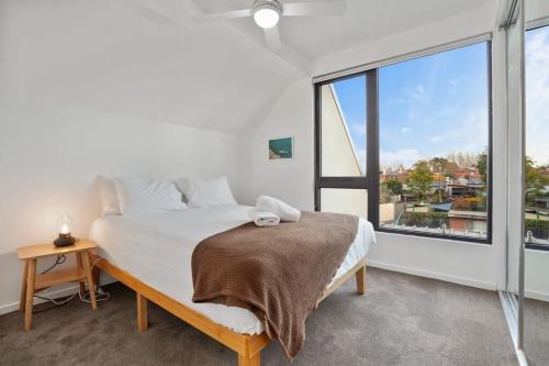 墨尔本Green getaway 1 Bedder Loft@ St kilda with parking的一间卧室设有一张床和一个大窗户