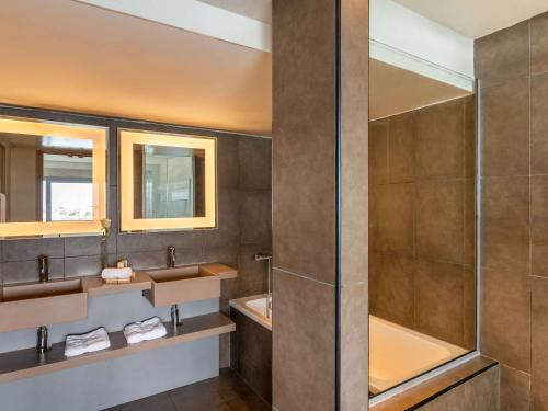 阿比让阿比让诺富特酒店的一间带两个盥洗盆和淋浴的浴室