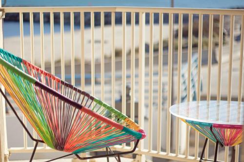 圣马迪拉莫卡米尔酒店的沙滩前的五颜六色的椅子和桌子
