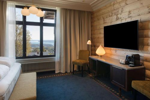 奥斯陆斯堪的克霍门科伦公园酒店的酒店客房配有书桌和电视。