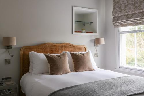 GoudhurstThe Goudhurst Inn的一间卧室配有带白色床单和枕头的床。