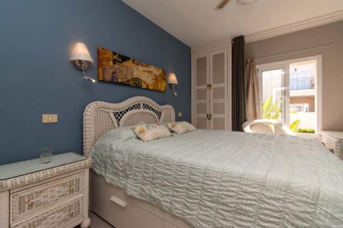 阿德耶Los Olivos 13 - One Bed的一间卧室设有一张床和蓝色的墙壁