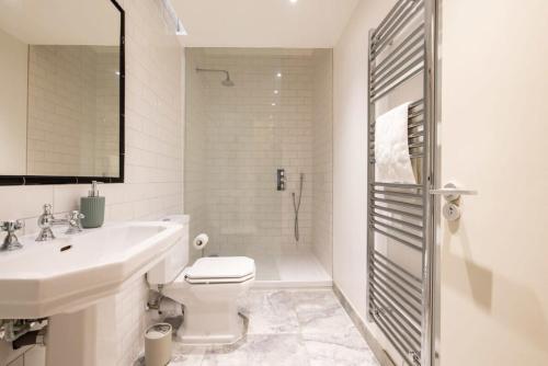 伦敦Central Soho Loft with A C & Concierge的浴室配有卫生间、盥洗盆和淋浴。