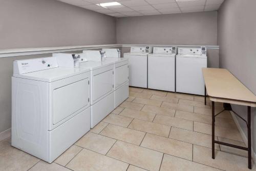 巴尔的摩Super 8 by Wyndham Baltimore Northwest的洗衣房配有白色洗衣机和桌子