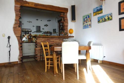 滨海阿热莱斯Maison rue de la paix Centre historique Argeles sur Mer的厨房配有桌椅和砖墙