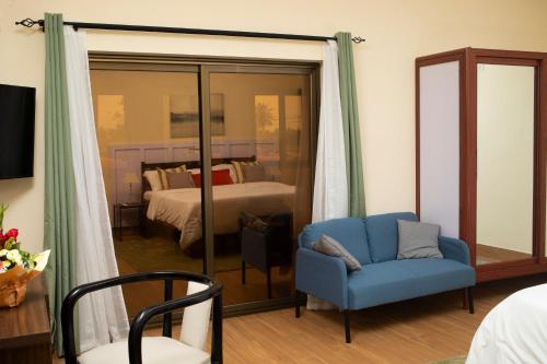 洛美乐佩里堪酒店的一间设有蓝色椅子的房间和一间卧室