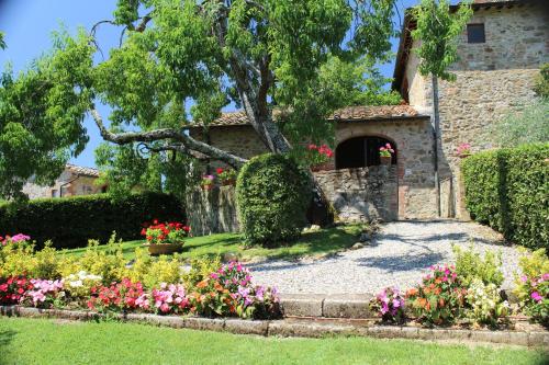 San GusmèArco al Poggio - Arceno Rentals Club的一座花园,在一座建筑前种有鲜花