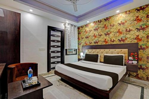 新德里Hotel De Huespedes near international airport的一间卧室配有一张带花卉壁纸的大床