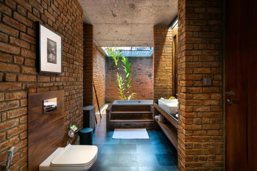 哈伯勒内Taru Villas Maia - Habarana的砖砌浴室设有浴缸和卫生间