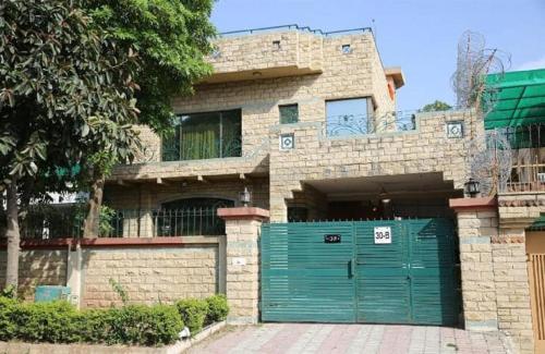 伊斯兰堡Islamabad Lodges的前面有绿色车库门的房子