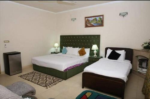 伊斯兰堡Islamabad Lodges的一间带两张床和一张沙发的卧室