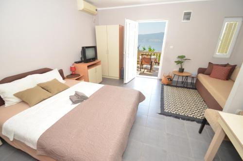 蒂瓦特Porto Lastva Apartments的一间卧室配有一张床,客厅配有沙发