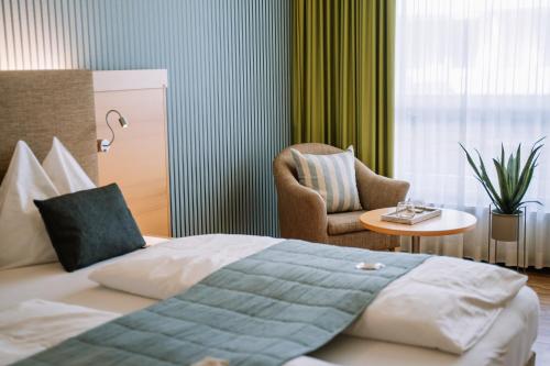 圣兰布雷希特Hotel Auszeit St Lambrecht的配有一张床和一把椅子的酒店客房