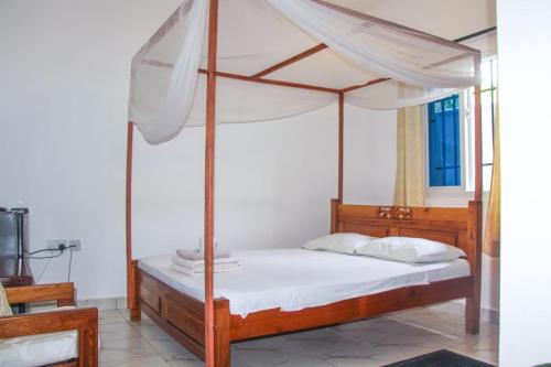 姆特瓦帕Anna Estate的卧室配有带白色床单的天蓬床