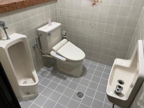 宜野湾市Joyful Rose的一间带卫生间、小便器和盥洗盆的浴室
