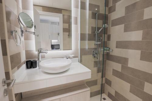 迪拜Cosy Studio at Palm Jumeirah的浴室设有白色水槽和镜子