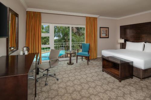 约翰内斯堡Holiday Inn - Johannesburg Sunnyside Park, an IHG Hotel的酒店客房配有一张床、一张书桌、一张床和一张书桌。