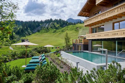 莱赫阿尔贝格莫嫩弗鲁酒店的山边带游泳池的房子