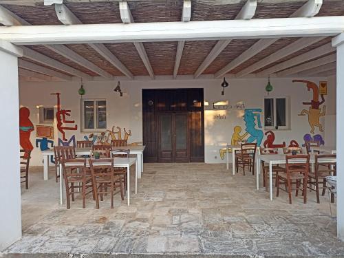 奥斯图尼B&B La casa degli artisti的用餐室配有桌椅和壁画