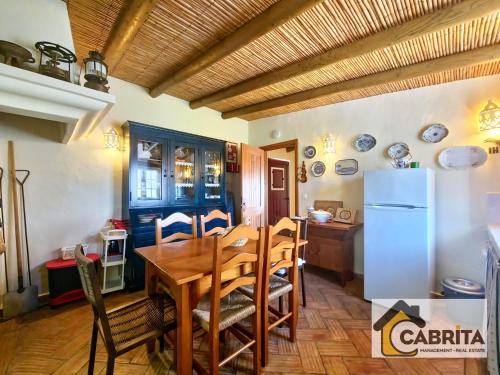 阿尔图拉Quinta dos Medronheiros的厨房以及带桌子和冰箱的用餐室