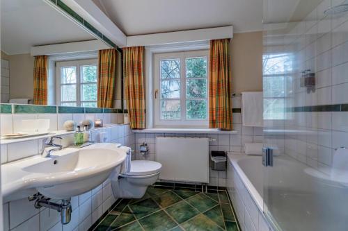 ZarrentinSeehotel Zarrentin的浴室配有盥洗盆、卫生间和浴缸。