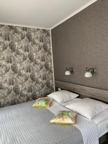 利沃夫Yurus Hostel的一间卧室配有两张带枕头和壁纸的床