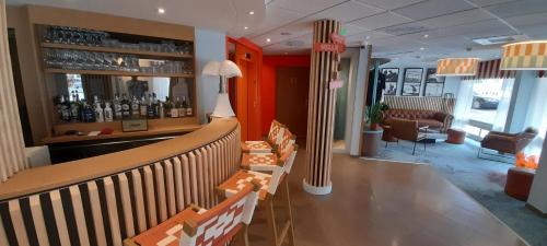 比亚里茨Hôtel AKENA Biarritz - Grande plage的餐厅内的酒吧配有椅子和柜台