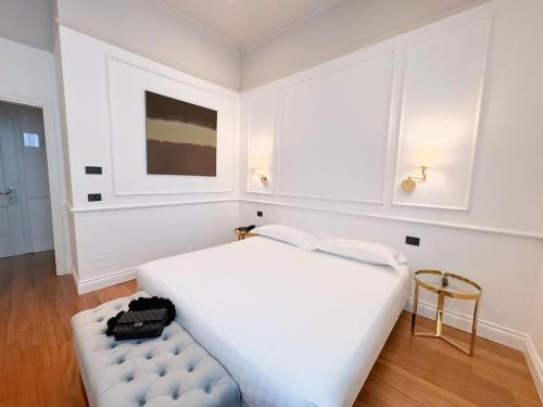 摩德纳雷齐吉公园酒店的白色的卧室配有白色的床和凳子